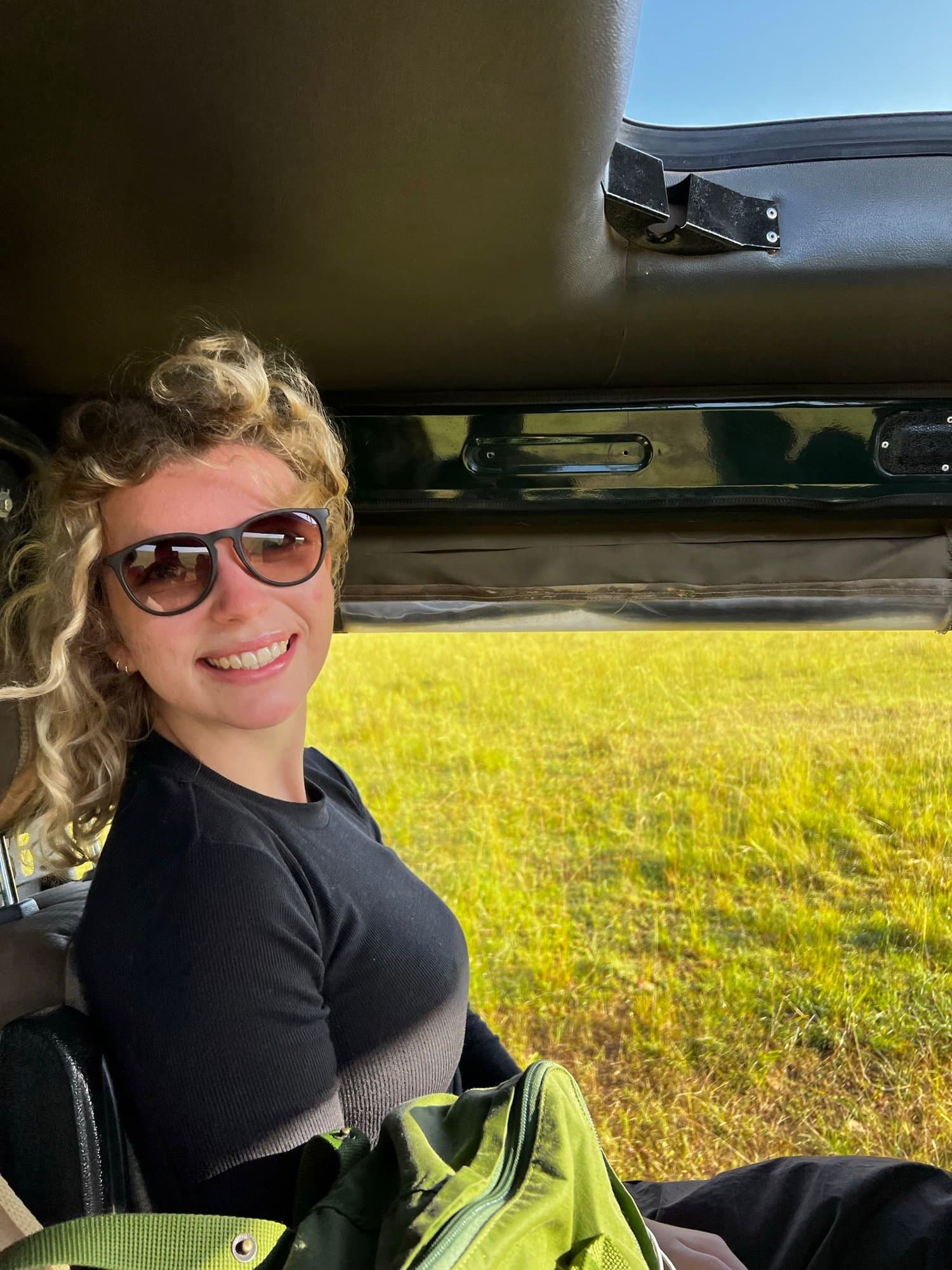 Traveler smiling from the safari vehicle on a game drive