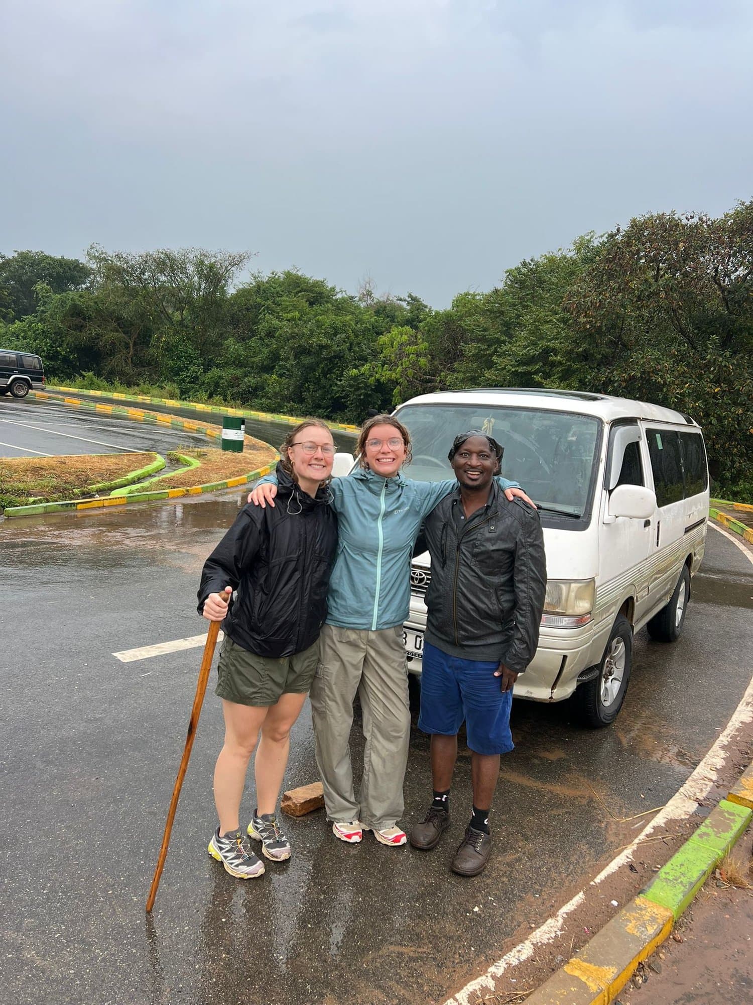 Travelers with their guide beside the safari van