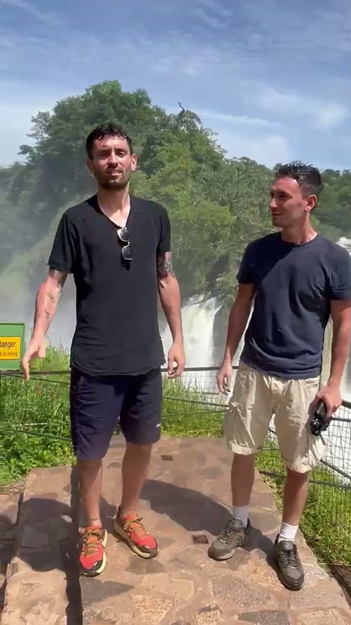 Travelers at a waterfall viewpoint overlooking the mist