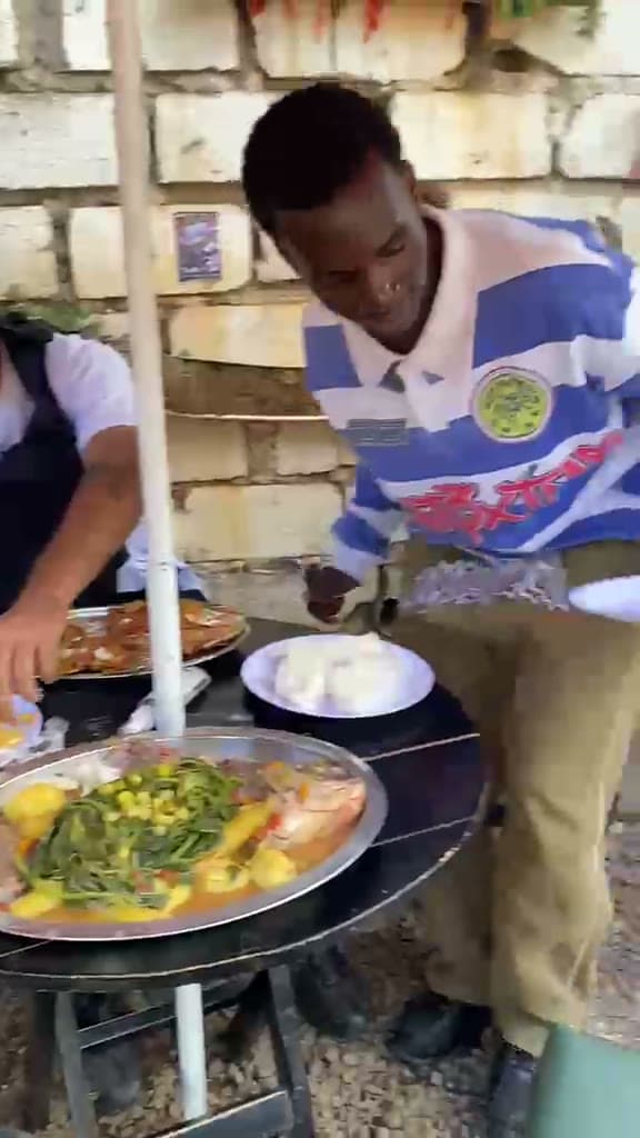 Local lunch of fish stew, greens and posho being served