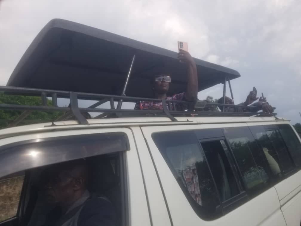 Travelers photographing wildlife from a pop-up safari van